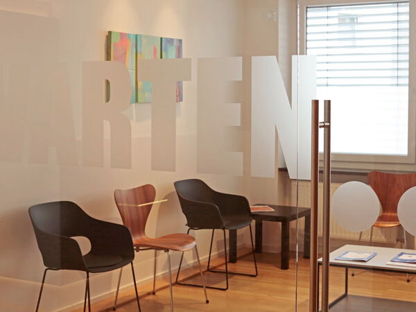 Designorientiertes Wartezimmer mit harmonischem Farbkonzept und freundlichem Ambiente.